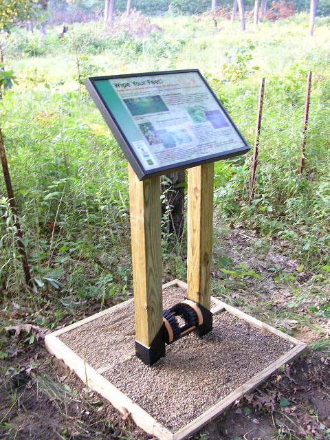 Image of boot brush station on hiking trail.